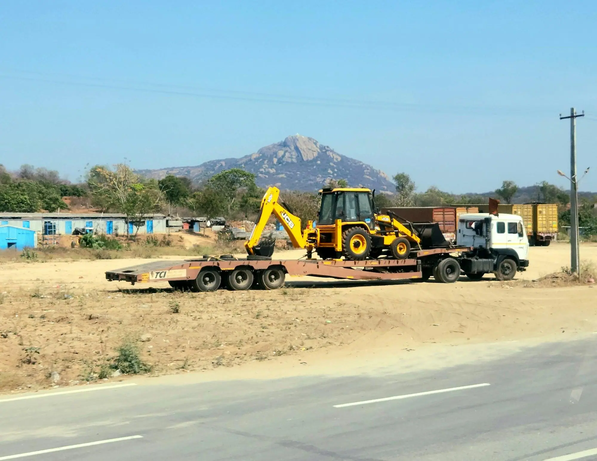 Backhoe loader loaded on a trailer on an Indian highway